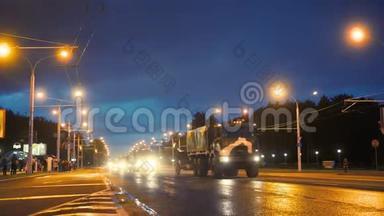 一支军事装备车队在夜间乘坐大灯穿过城市